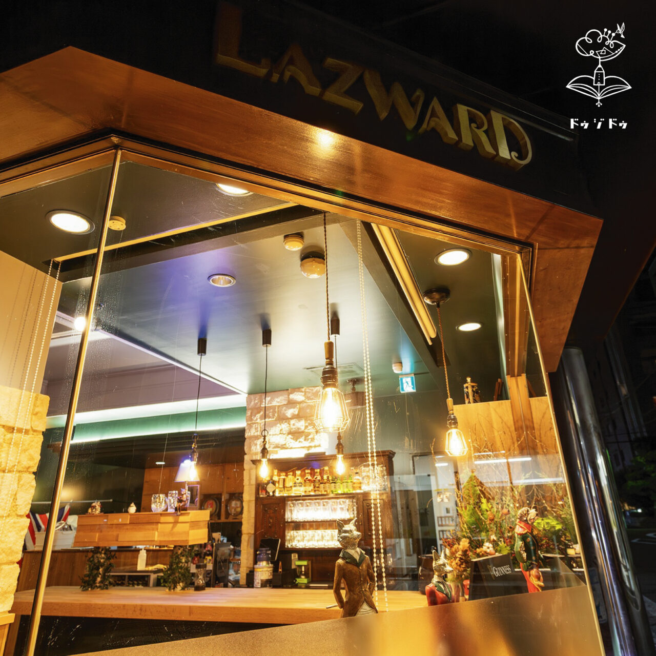 道路から見えるのはお酒が並んだアンティーク家具とコッツウォルズストーンです